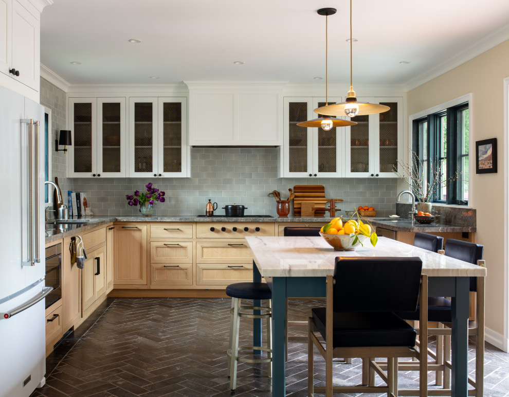This is an example of a mid-sized transitional u-shaped eat-in kitchen in Los Angeles with a double-bowl sink, beaded inset cabinets, light wood cabinets, quartzite benchtops, blue splashback, subway tile splashback, panelled appliances, ceramic floors, no island, black floor and grey benchtop.