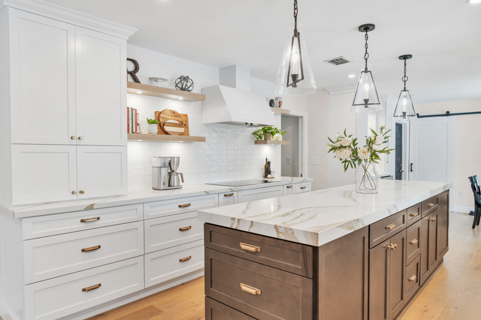 Open concept kitchen - large transitional medium tone wood floor and brown floor open concept kitchen idea in Miami with shaker cabinets, white cabinets, quartz countertops, white backsplash, subway tile backsplash, stainless steel appliances, an island, white countertops and a farmhouse sink