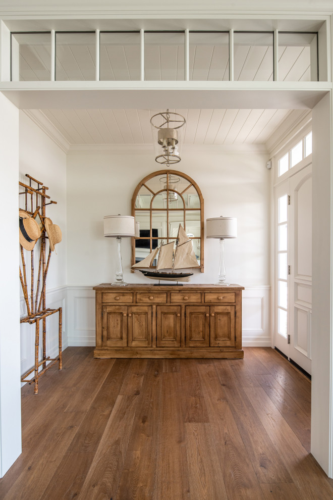 Design ideas for a foyer in San Diego with white walls, medium hardwood floors, a single front door, a white front door, wood and decorative wall panelling.
