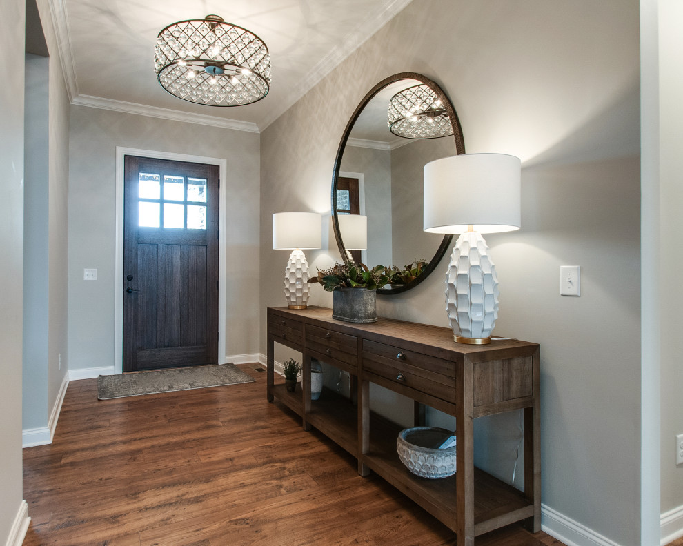 This is an example of a mid-sized transitional foyer in Nashville with grey walls, medium hardwood floors, a single front door, a dark wood front door and brown floor.