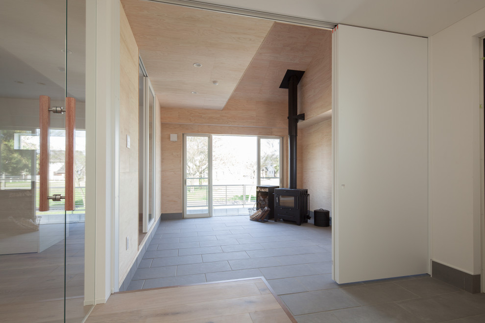 他の地域にある中くらいなおしゃれな玄関ロビー (白い壁、セラミックタイルの床、白いドア、グレーの床) の写真