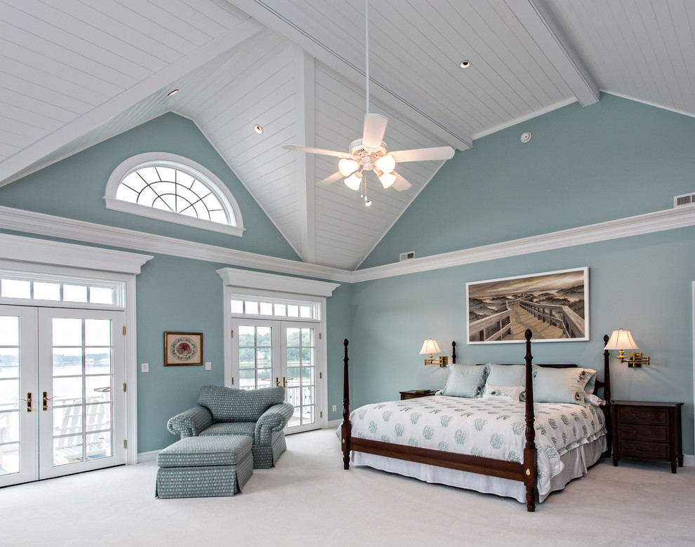 Photo of a large beach style master bedroom in Other with blue walls and carpet.