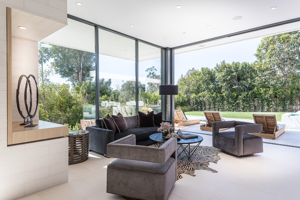 Large modern formal open concept living room in Los Angeles with white walls and limestone floors.