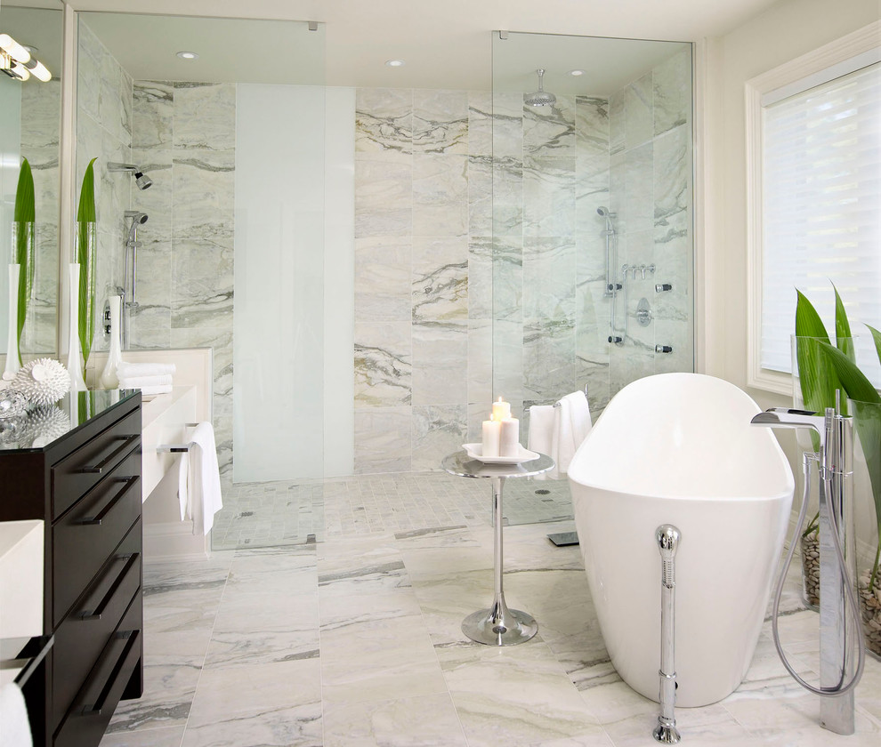Inspiration for a mid-sized contemporary master bathroom in Toronto with a curbless shower, flat-panel cabinets, dark wood cabinets, a freestanding tub, white tile, stone tile, white walls, marble floors and engineered quartz benchtops.