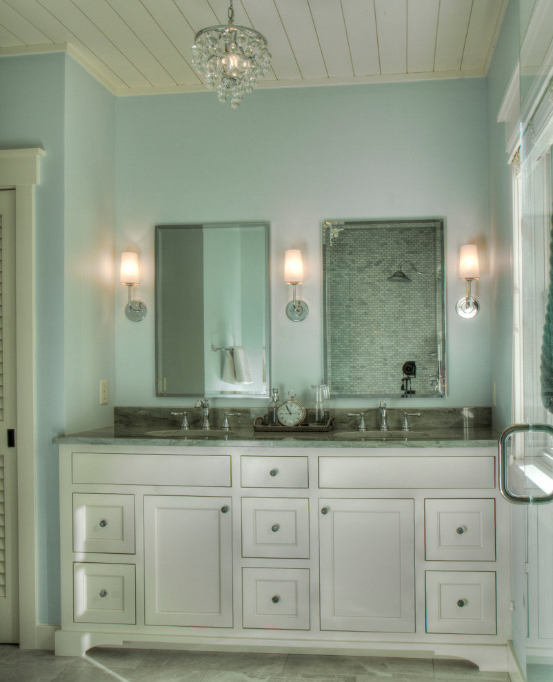 Example of a mid-sized transitional master porcelain tile, gray floor and double-sink bathroom design in Minneapolis with flat-panel cabinets, white cabinets, blue walls, an undermount sink, granite countertops, multicolored countertops and a built-in vanity