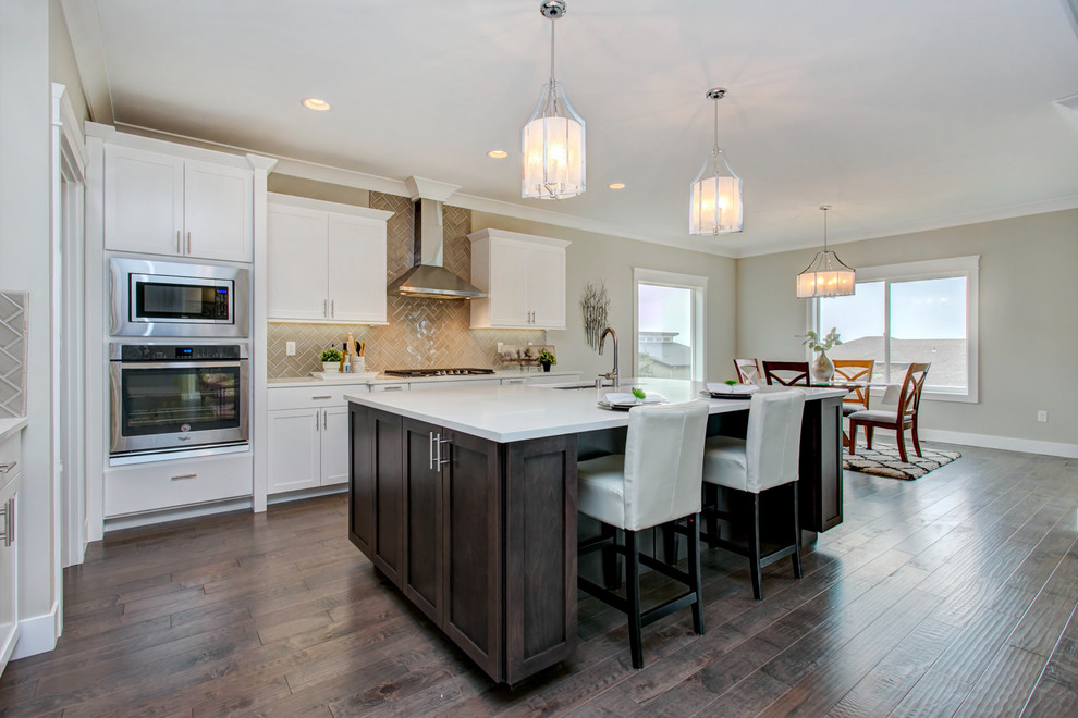 Large transitional l-shaped dark wood floor open concept kitchen photo in Seattle with an undermount sink, shaker cabinets, white cabinets, quartz countertops, gray backsplash, porcelain backsplash, stainless steel appliances, an island and white countertops