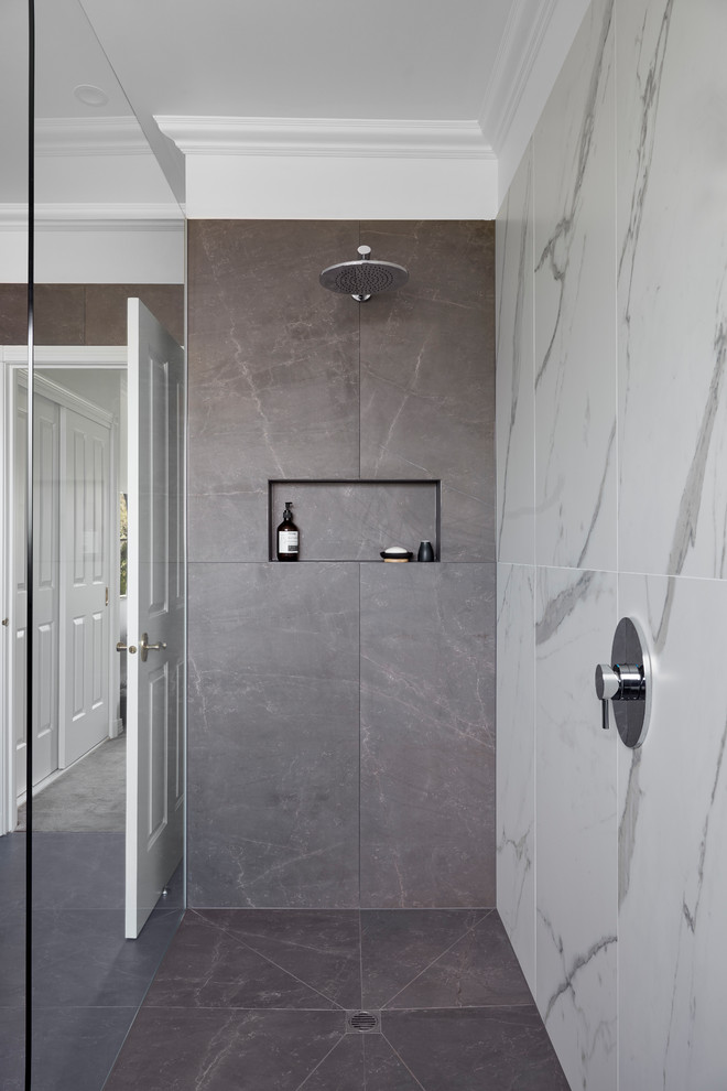 Inspiration for a large contemporary master bathroom in Melbourne with flat-panel cabinets, dark wood cabinets, a freestanding tub, an open shower, gray tile, a vessel sink, marble benchtops, a hinged shower door and white benchtops.