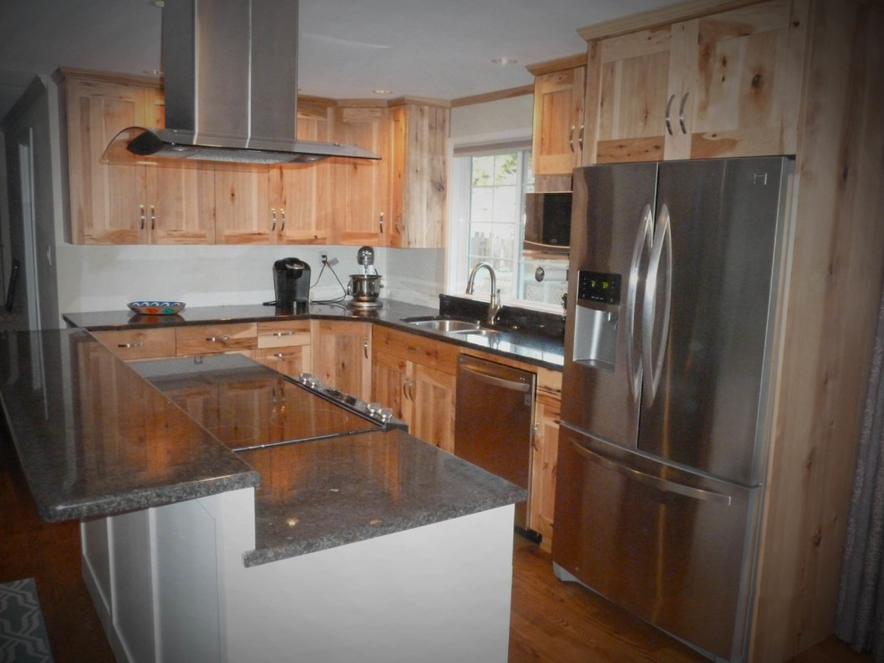 Example of a large mountain style u-shaped medium tone wood floor and brown floor eat-in kitchen design in Seattle with a double-bowl sink, shaker cabinets, light wood cabinets, granite countertops, stainless steel appliances and an island