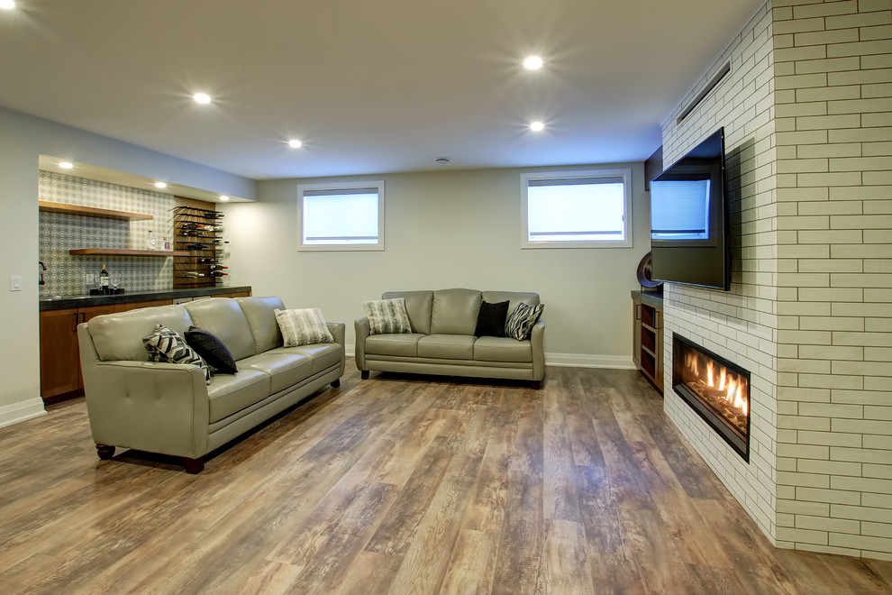 Design ideas for a mid-sized transitional look-out basement in Toronto with white walls, a ribbon fireplace and a brick fireplace surround.