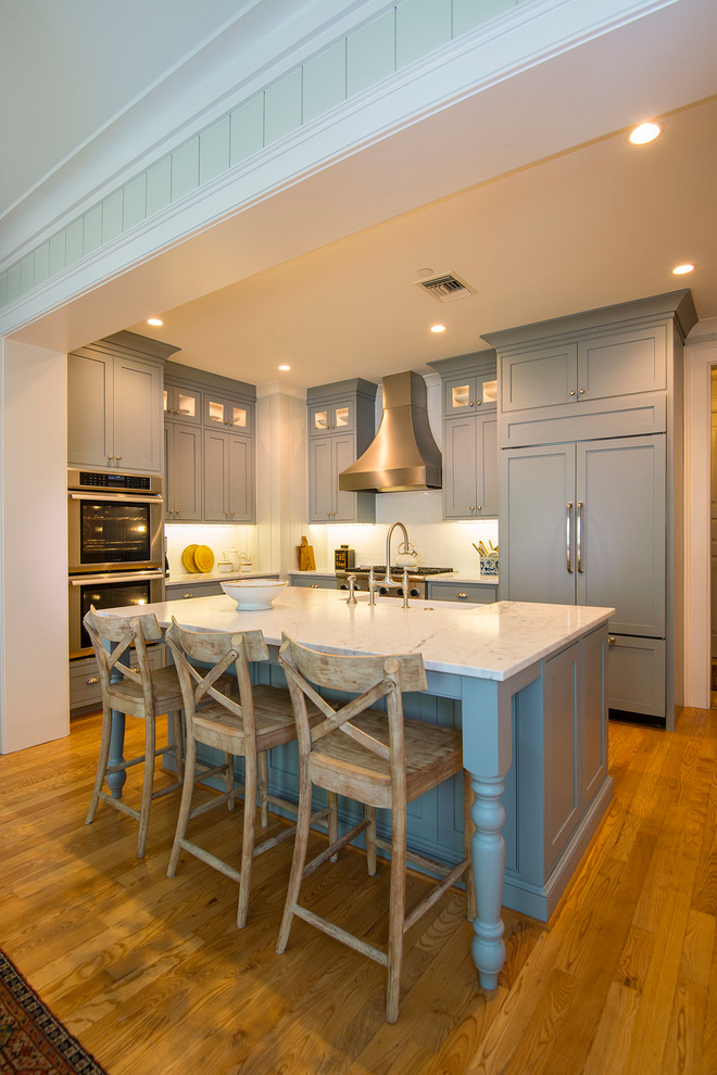 Inspiration for a small transitional l-shaped kitchen in Charleston with a farmhouse sink, beaded inset cabinets, green cabinets, marble benchtops, white splashback, stainless steel appliances, medium hardwood floors and with island.