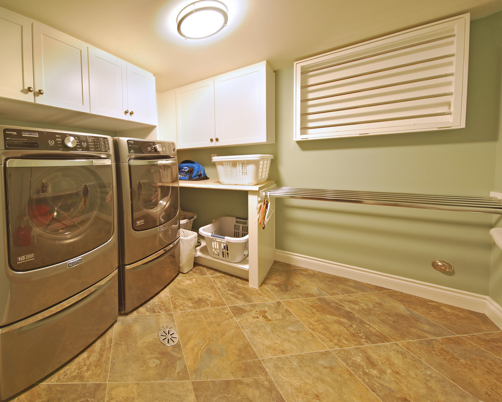 Mid-sized transitional l-shaped laundry cupboard in Edmonton with shaker cabinets, white cabinets, laminate benchtops, green walls, vinyl floors and a side-by-side washer and dryer.
