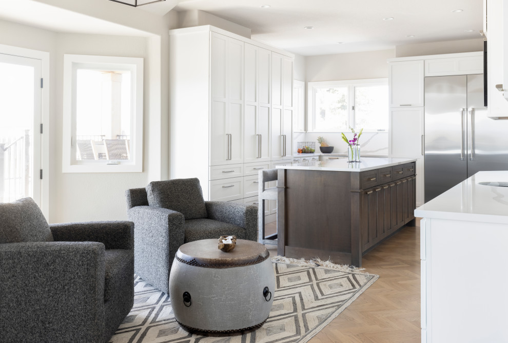 Example of a large transitional l-shaped light wood floor enclosed kitchen design in Denver with a double-bowl sink, shaker cabinets, gray cabinets, quartz countertops, white backsplash, quartz backsplash, stainless steel appliances, two islands and white countertops