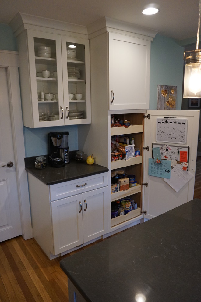 Inspiration for a mid-sized transitional u-shaped medium tone wood floor eat-in kitchen remodel in Boston with an undermount sink, shaker cabinets, gray cabinets, quartz countertops, black backsplash, stainless steel appliances and an island