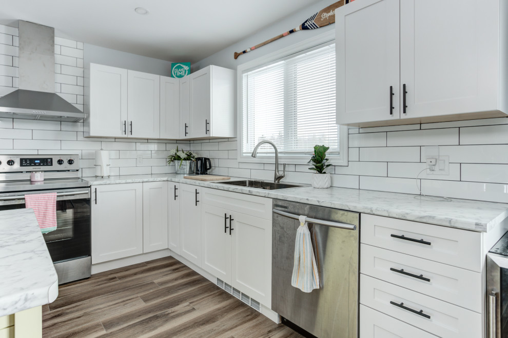 Inspiration for a modern vinyl floor and brown floor eat-in kitchen remodel in Toronto with shaker cabinets, white cabinets, ceramic backsplash and stainless steel appliances