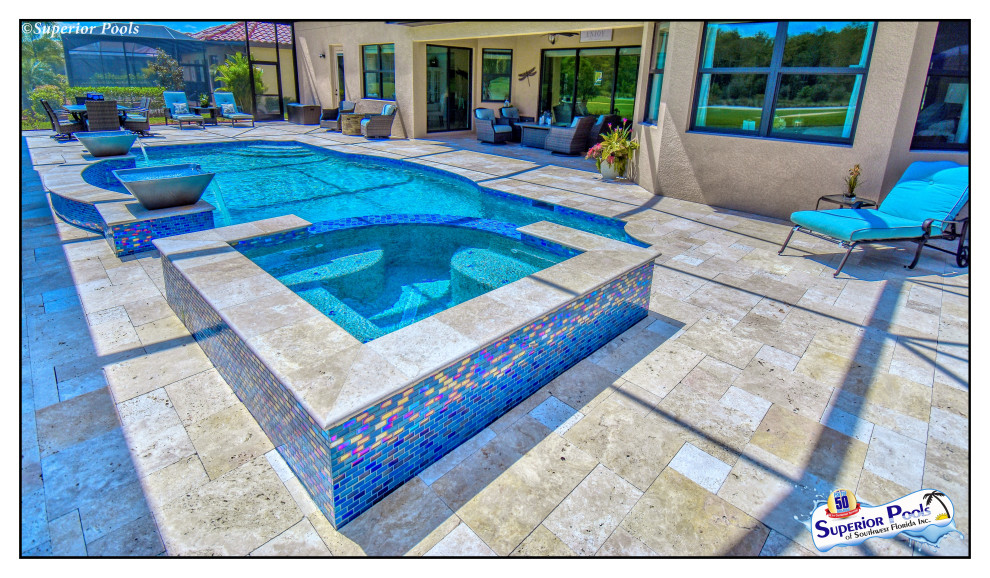 Photo of a large traditional backyard rectangular lap pool in Tampa with a pool house and natural stone pavers.