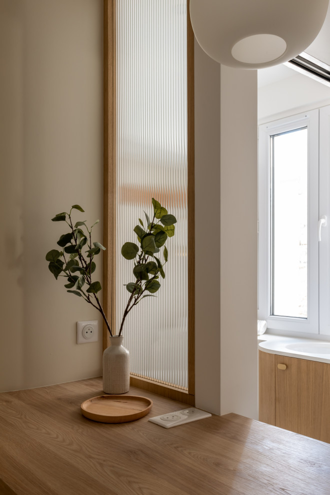 Imagen de entrada moderna pequeña con paredes blancas, suelo de madera clara y suelo beige