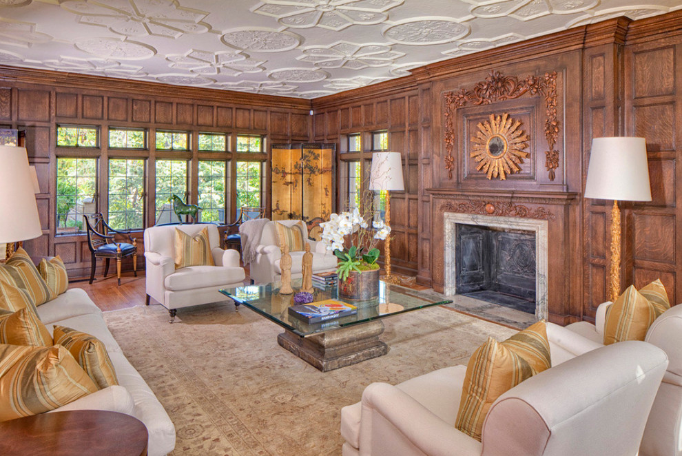 Large traditional formal enclosed living room in Los Angeles with medium hardwood floors, a standard fireplace, brown walls, a wood fireplace surround, no tv and brown floor.