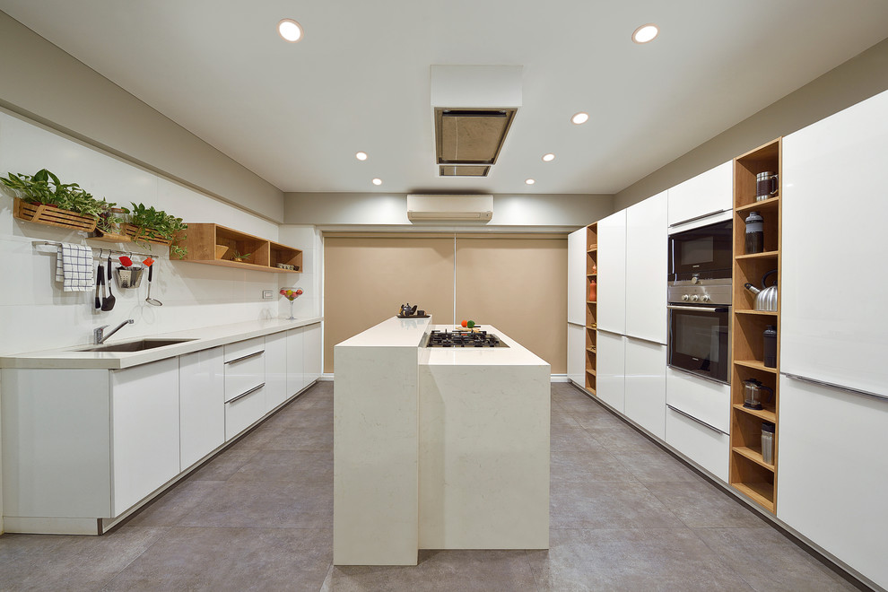 Design ideas for a mid-sized modern galley kitchen in Mumbai with flat-panel cabinets, white cabinets, quartz benchtops, white splashback, ceramic splashback, stainless steel appliances, with island, grey floor and beige benchtop.