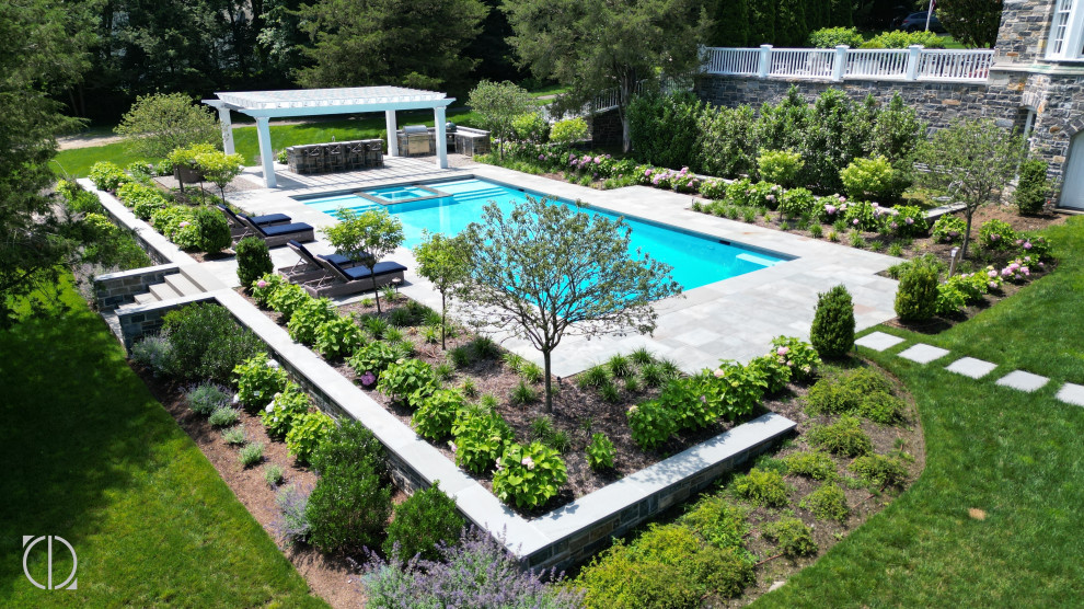 Pool landscaping - large backyard stone and rectangular pool landscaping idea