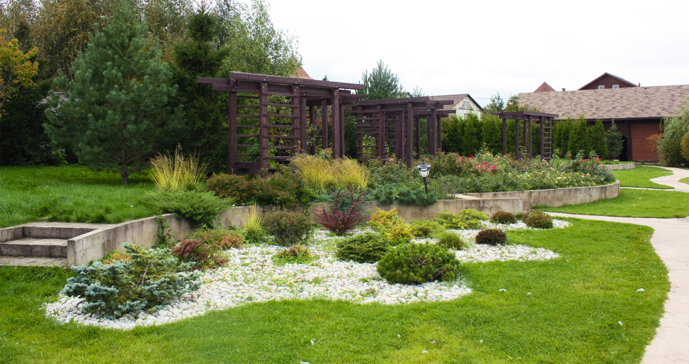 Esempio di un grande giardino xeriscape chic esposto in pieno sole in autunno con un pendio, una collina o una riva, sassi di fiume e recinzione in pietra