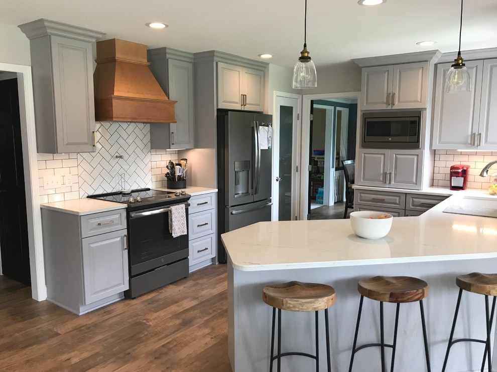 Enclosed kitchen - mid-sized transitional u-shaped vinyl floor and brown floor enclosed kitchen idea with an undermount sink, raised-panel cabinets, gray cabinets, quartz countertops, white backsplash, ceramic backsplash, a peninsula and white countertops