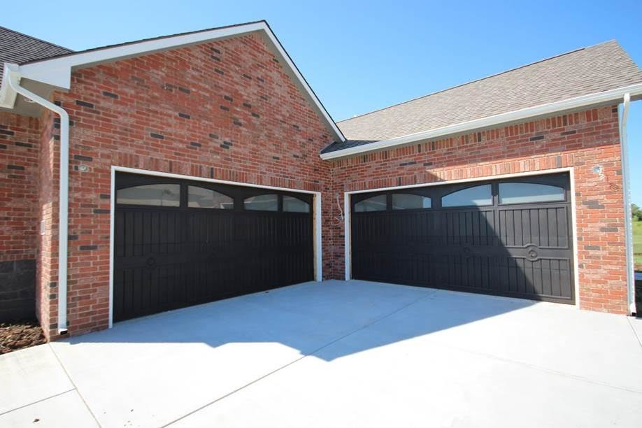 This is an example of a mid-sized traditional attached four-car garage in Wichita.
