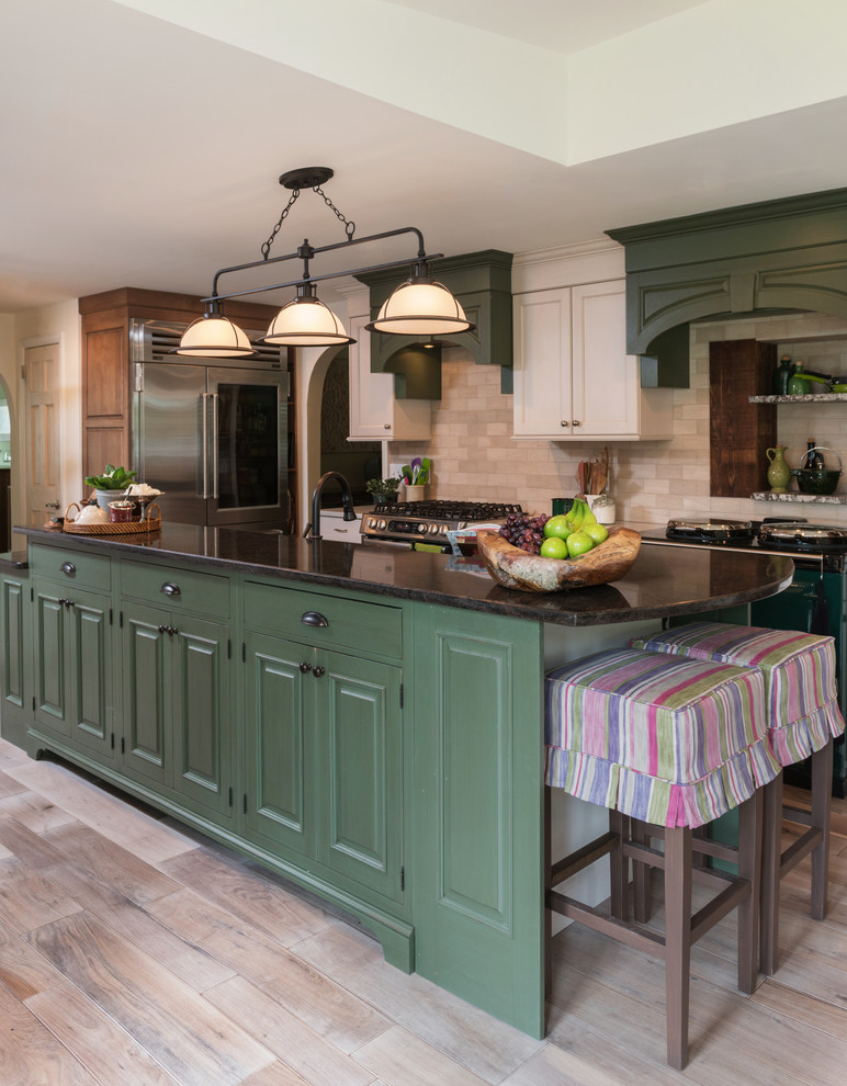 Inspiration for a large country galley eat-in kitchen in Philadelphia with an undermount sink, raised-panel cabinets, green cabinets, quartz benchtops, beige splashback, stone tile splashback, coloured appliances, light hardwood floors, with island and beige floor.