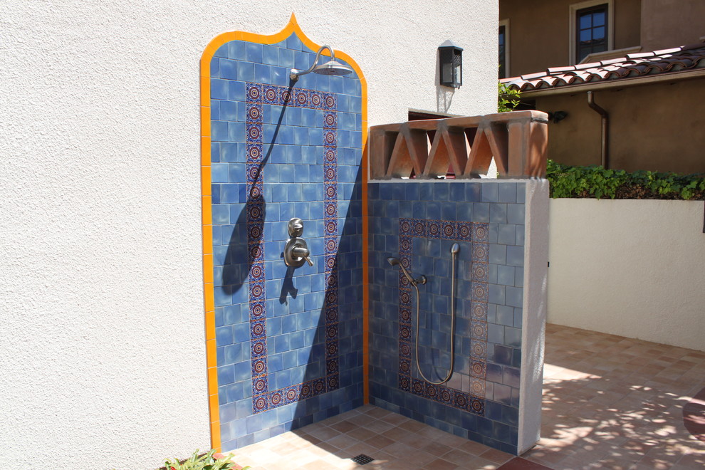 This is an example of a small mediterranean backyard patio in San Diego with an outdoor shower, tile and no cover.