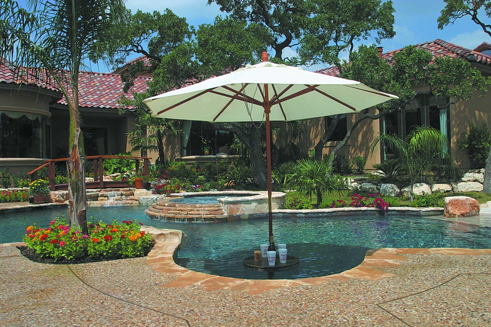 Photo of a large mediterranean backyard custom-shaped pool in Austin with a hot tub and gravel.
