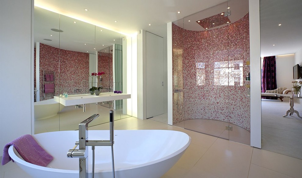 Large contemporary master bathroom in London with glass-front cabinets, white cabinets, a freestanding tub, an open shower, pink tile, mosaic tile, white walls, porcelain floors, a wall-mount sink, beige floor, a hinged shower door, a double vanity and a floating vanity.