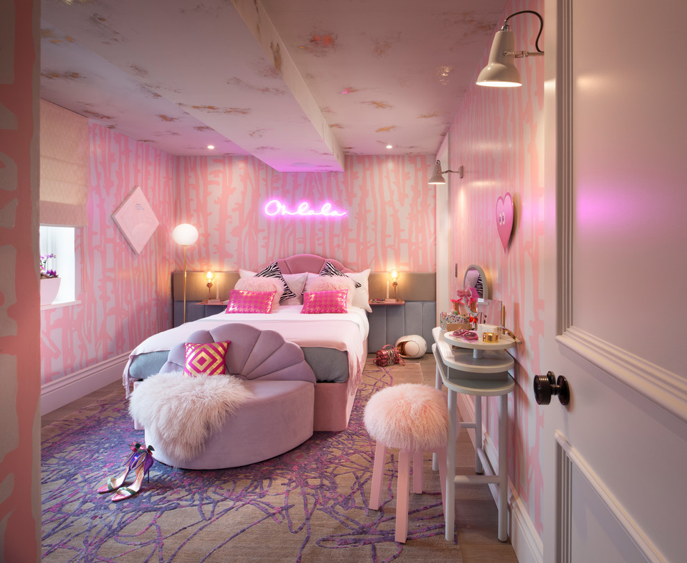 This is an example of a mid-sized contemporary bedroom in London with pink walls, medium hardwood floors and brown floor.