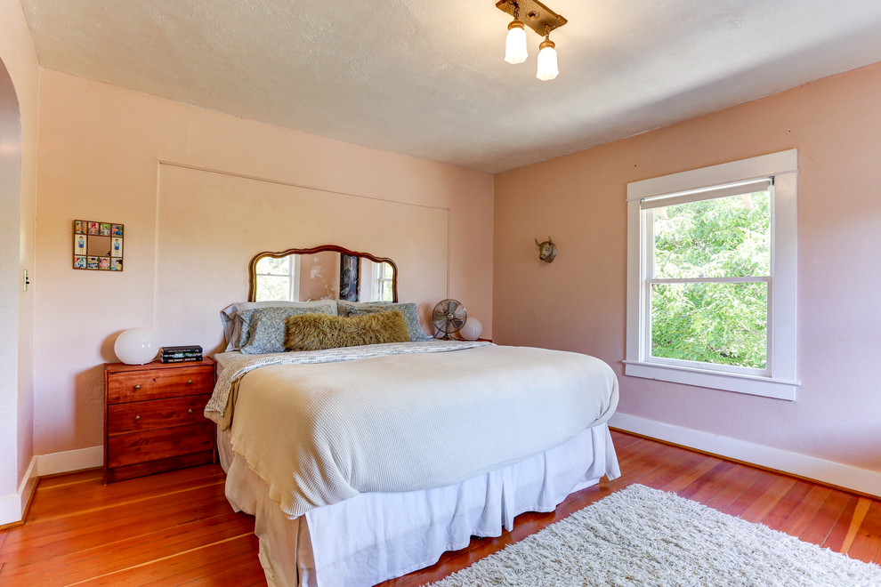 Inspiration for a mid-sized eclectic master bedroom in Portland with pink walls, light hardwood floors and no fireplace.