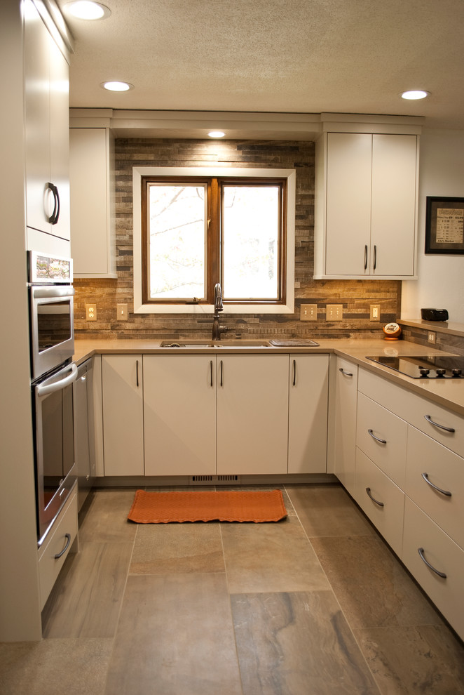 Example of a mid-sized transitional u-shaped eat-in kitchen design with an undermount sink, flat-panel cabinets, gray cabinets, brown backsplash, wood backsplash, stainless steel appliances and a peninsula