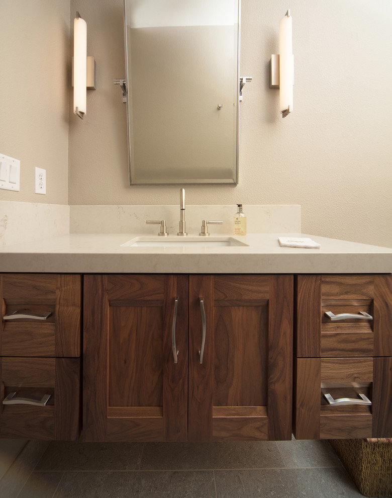 This is an example of a mid-sized contemporary 3/4 bathroom in San Luis Obispo with recessed-panel cabinets, dark wood cabinets, beige walls, porcelain floors, an undermount sink, quartzite benchtops and grey floor.