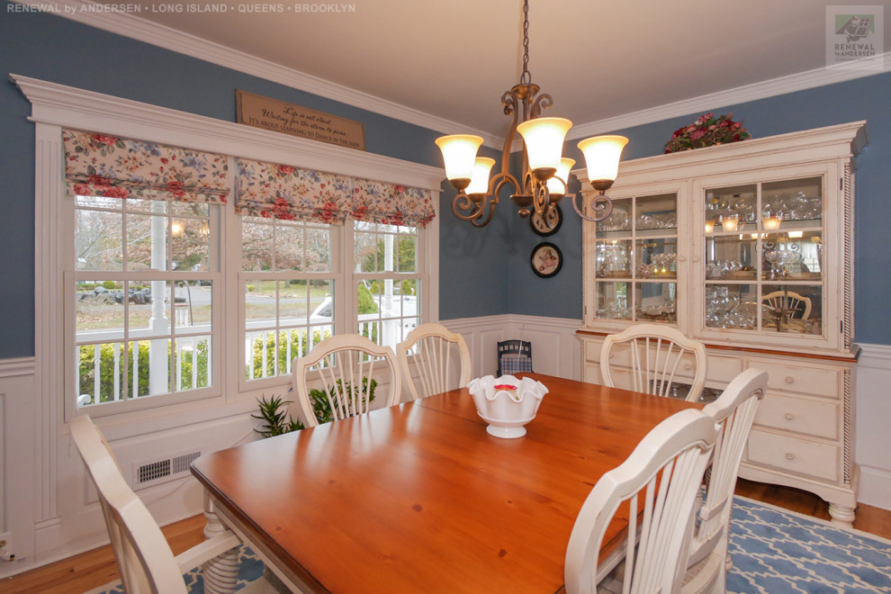 Foto di una sala da pranzo chiusa e di medie dimensioni con pareti blu, pavimento in legno massello medio, nessun camino, pavimento blu e boiserie