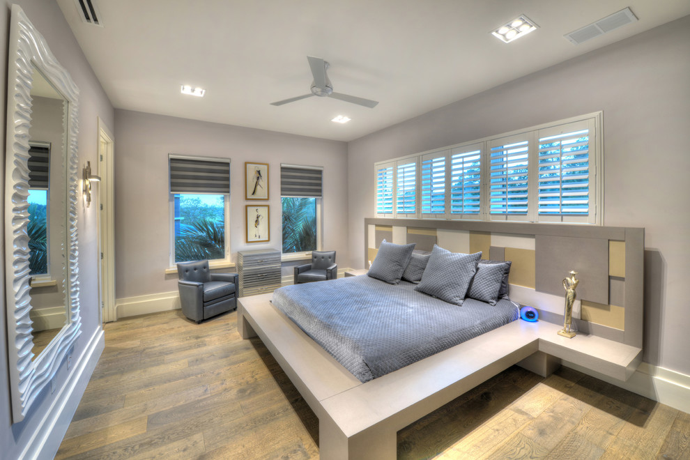 This is an example of a contemporary bedroom in Orlando with grey walls, medium hardwood floors and brown floor.