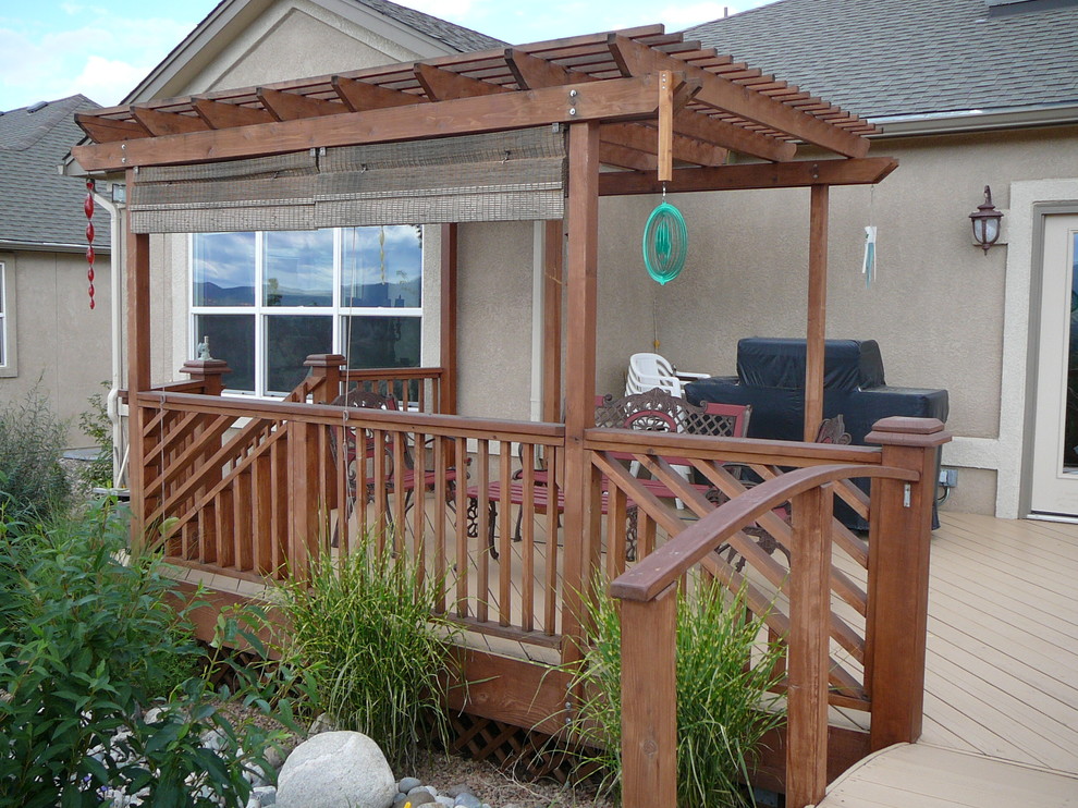 Mid-sized mountain style backyard deck photo in Denver with a pergola