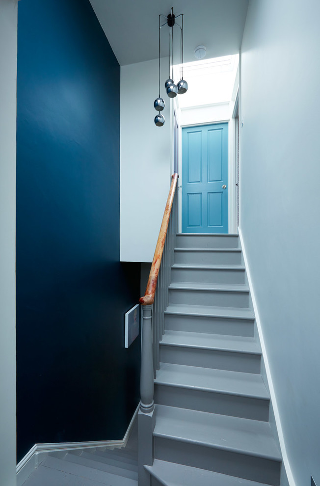 Design ideas for a midcentury hallway in London with painted wood floors.