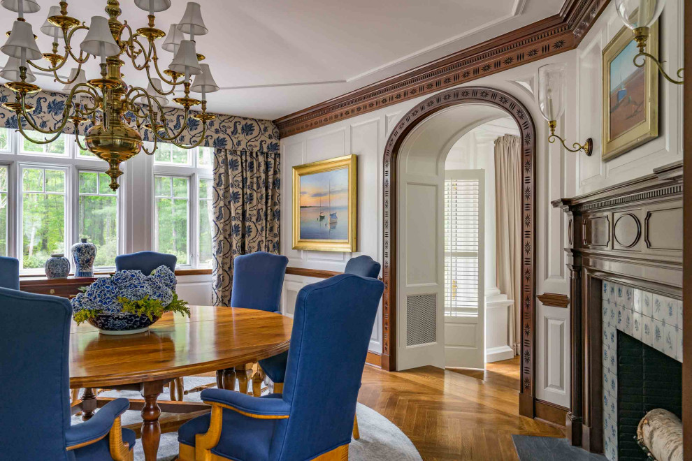 Photo of a traditional separate dining room in Boston with white walls, medium hardwood floors, a standard fireplace, a tile fireplace surround, brown floor, vaulted, panelled walls and decorative wall panelling.