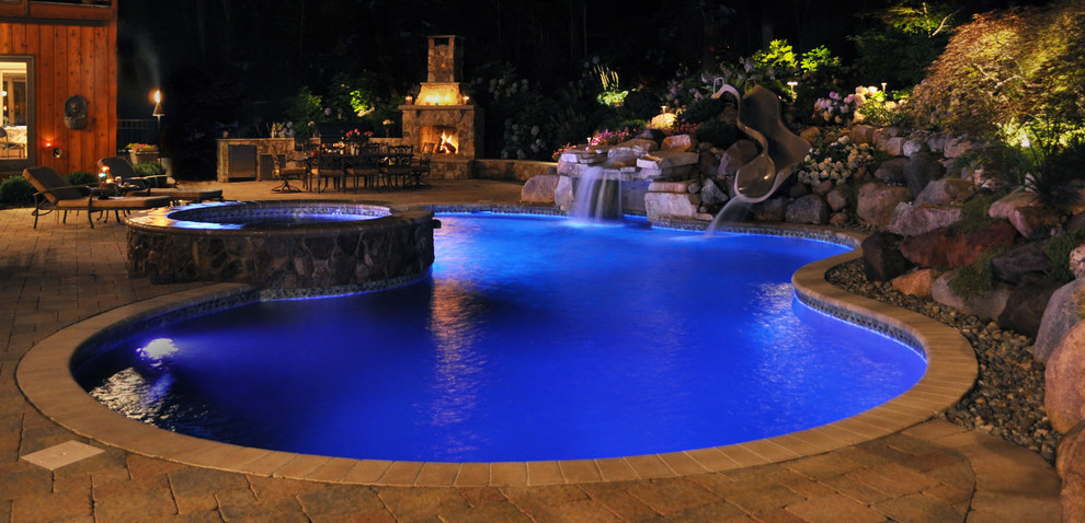 This is an example of a traditional custom-shaped pool in New York with concrete pavers.