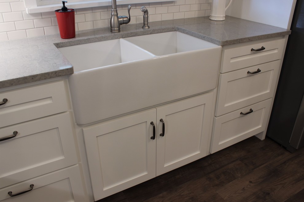 Inspiration for a mid-sized country l-shaped separate kitchen in Other with a farmhouse sink, shaker cabinets, white cabinets, quartz benchtops, white splashback, subway tile splashback, stainless steel appliances, linoleum floors and no island.