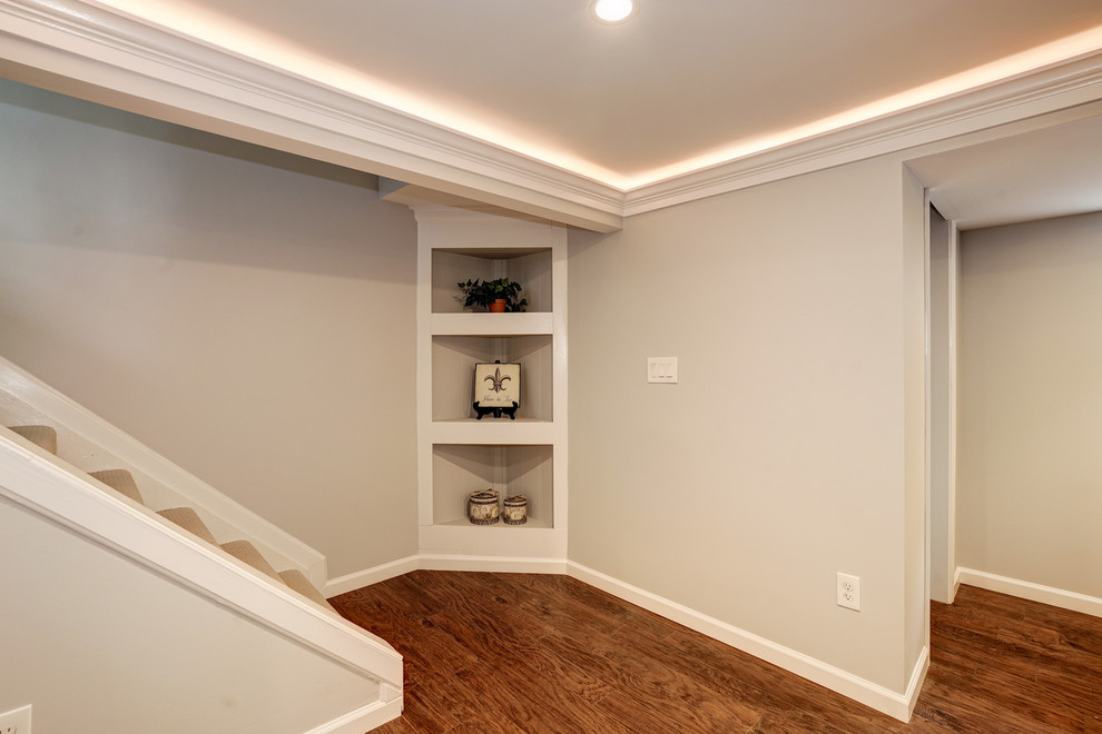 This is an example of a mid-sized traditional look-out basement in DC Metro with grey walls, dark hardwood floors, no fireplace and brown floor.