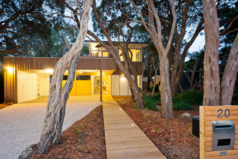 Photo of a contemporary two-storey beige exterior in Geelong with wood siding and a flat roof.