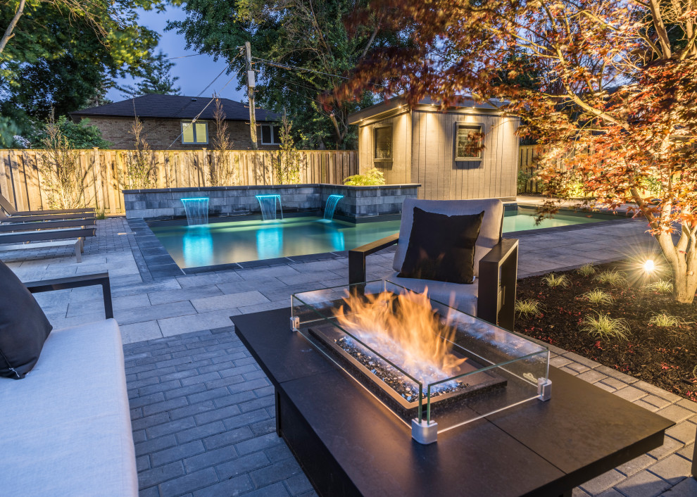 Pool fountain - mid-sized transitional backyard concrete paver and l-shaped lap pool fountain idea in Toronto