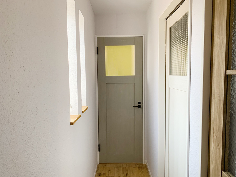 Réalisation d'un couloir minimaliste avec un mur blanc, un sol en bois brun, du papier peint, un sol marron et un plafond en papier peint.