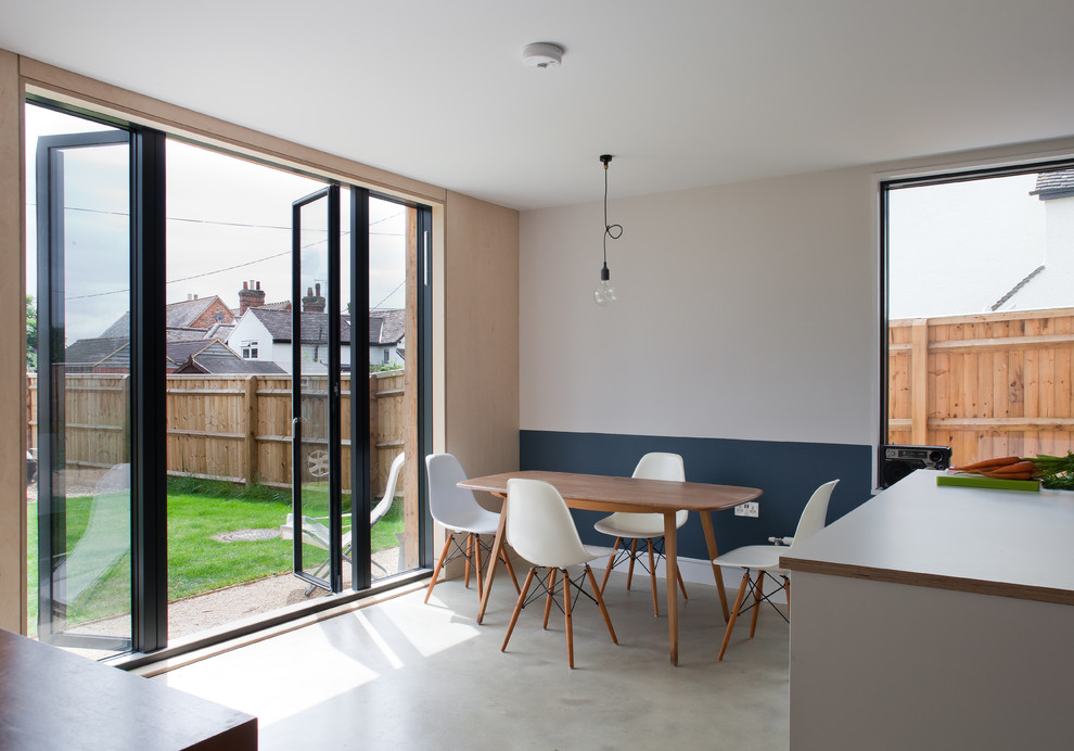 Photo of a mid-sized scandinavian open plan dining in Buckinghamshire with concrete floors, grey floor and multi-coloured walls.