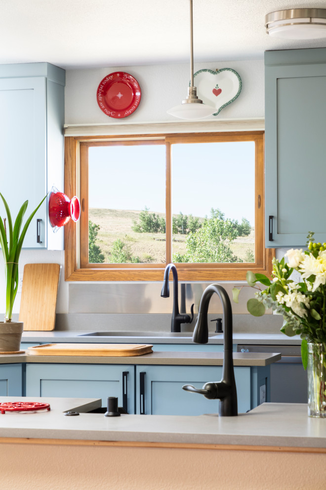Foto på ett mycket stort funkis grå kök, med en köksö, en undermonterad diskho, luckor med infälld panel, blå skåp, bänkskiva i kvarts, svarta vitvaror, vinylgolv och beiget golv