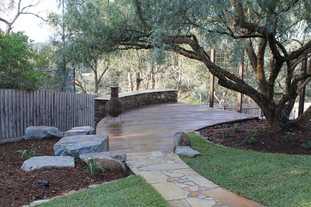 This is an example of a large country backyard full sun garden in Melbourne with decking.