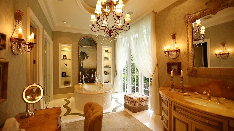 Inspiration for a large traditional master bathroom in Miami with shaker cabinets, medium wood cabinets, a drop-in tub, an alcove shower, brown walls, porcelain floors, an undermount sink, solid surface benchtops, beige floor and a hinged shower door.
