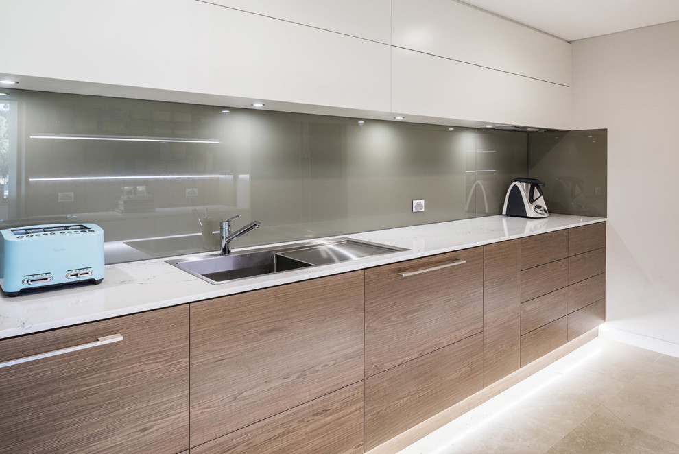 Design ideas for a large contemporary galley kitchen in Perth with a single-bowl sink, flat-panel cabinets, white cabinets, quartz benchtops, glass sheet splashback, limestone floors, no island and beige floor.